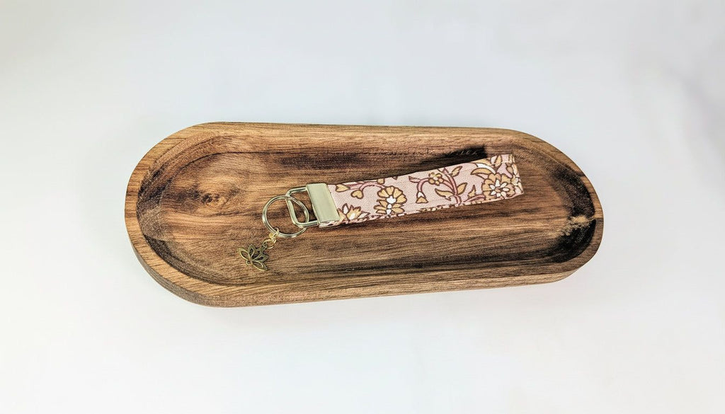 A wooden tray with a keychain attached to it.