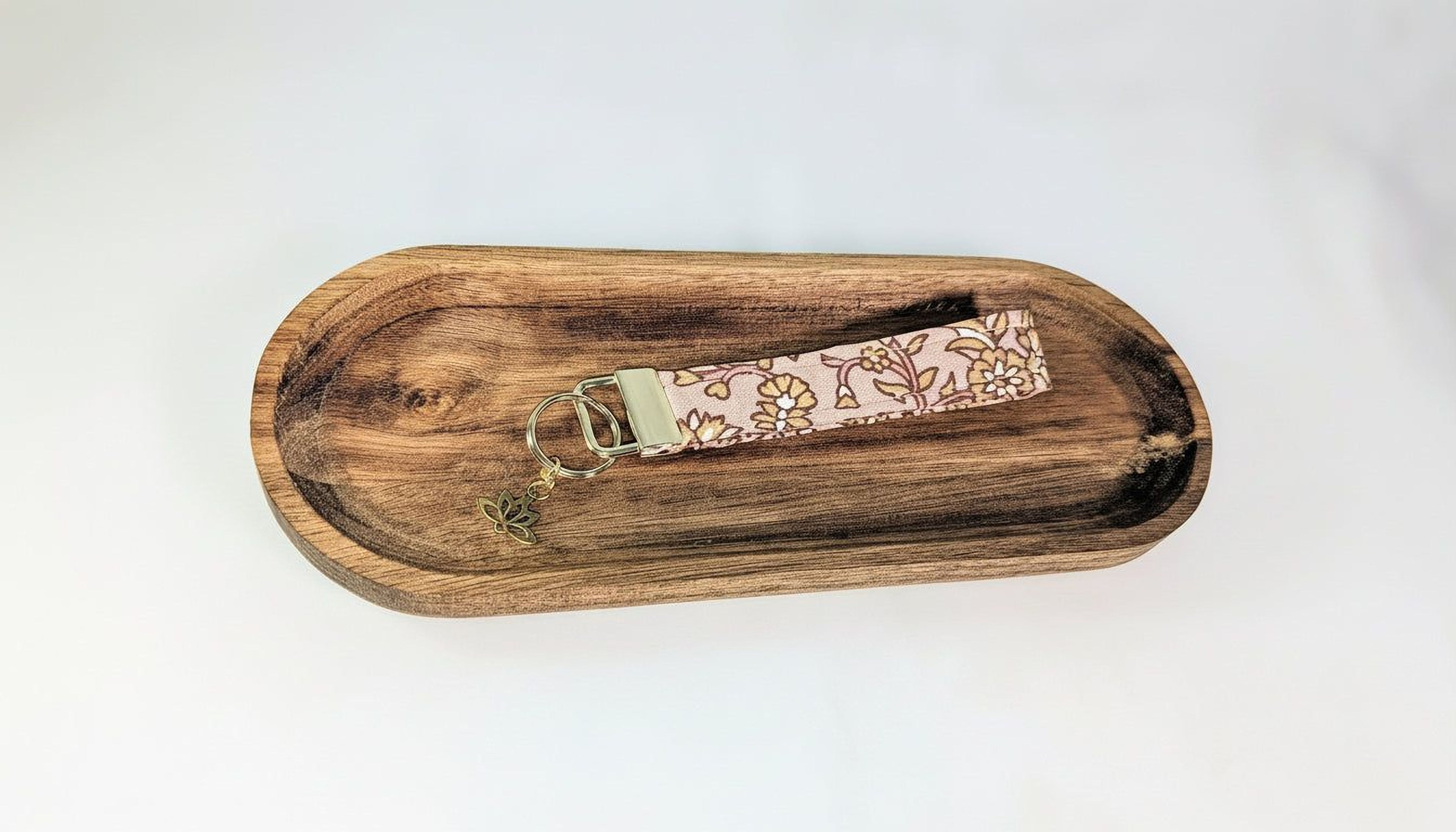A wooden tray with a keychain attached to it.