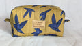 A yellow and blue quilted bag with a bird pattern, featuring a small label with text on it.