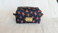 A black and pink floral makeup bag with a gold label that says "Mélodie de la sécurité".