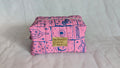 A pink and blue patterned bag with a gold-colored tag that says "Ma tu vous en love".