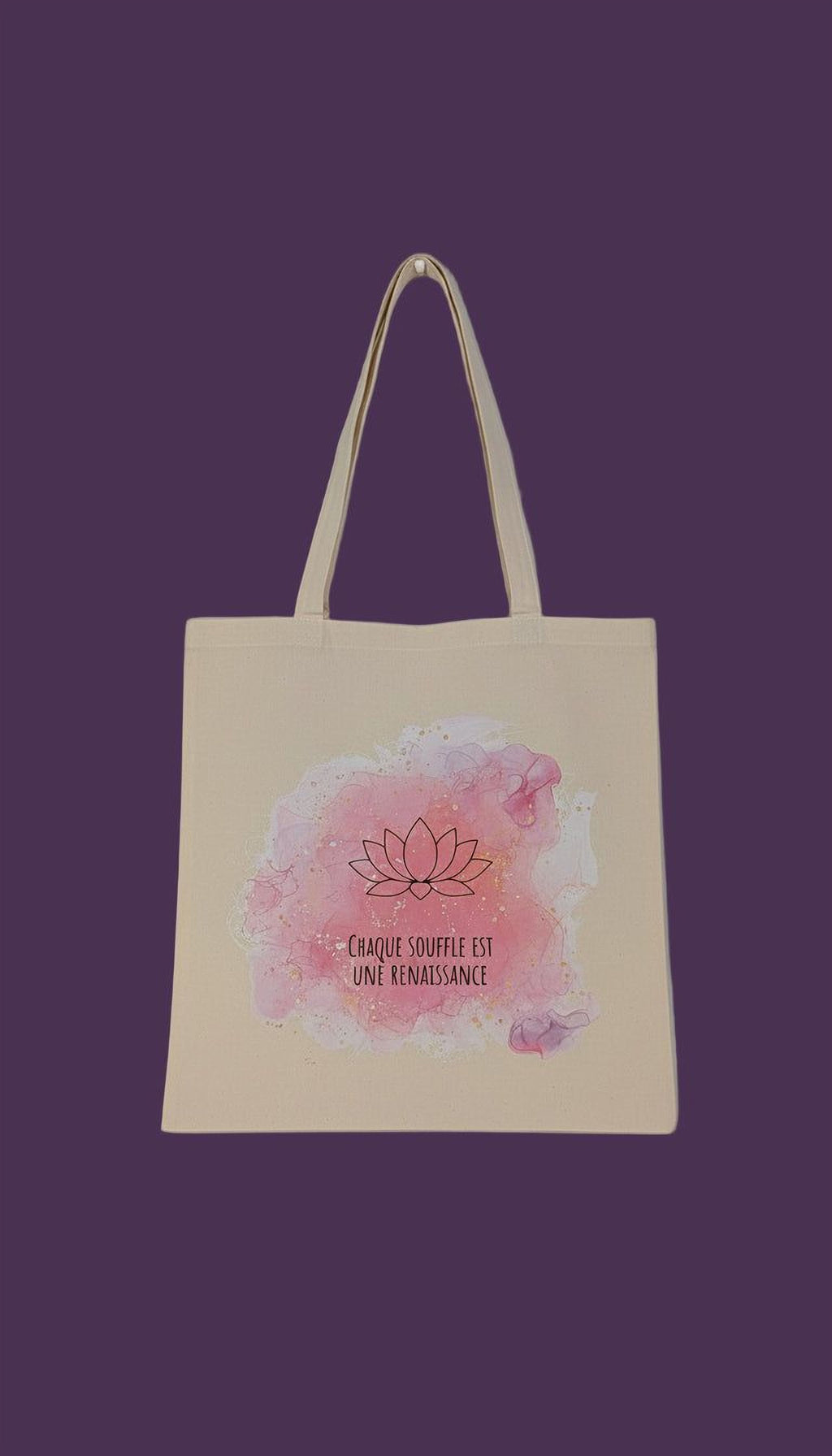 A beige tote bag with a watercolor design featuring a lotus flower and the text "Chaque souffle est une renaissance" (The lotus is a symbol of renaissance).